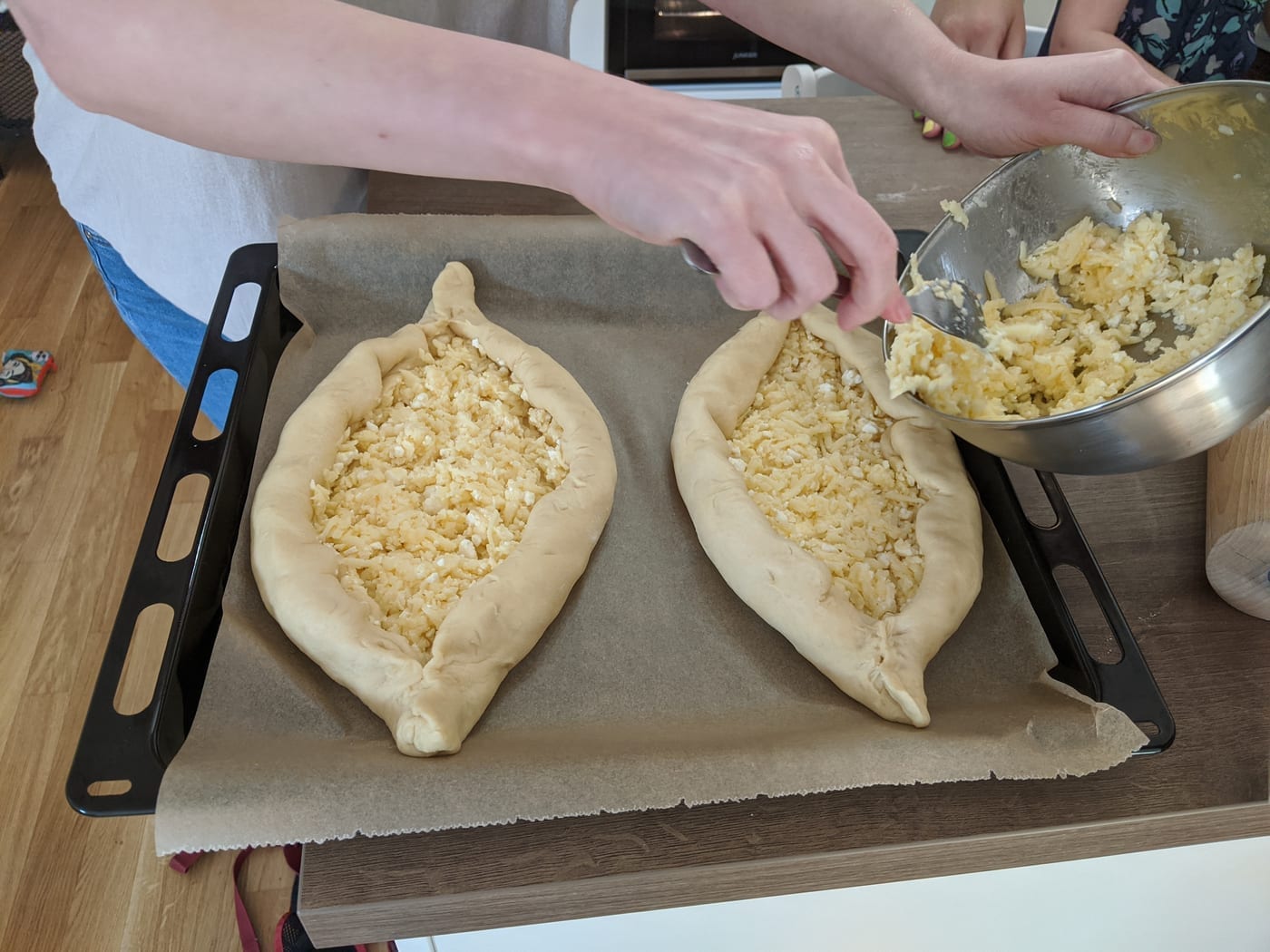 Shaping Adjarian khachapuri before baking