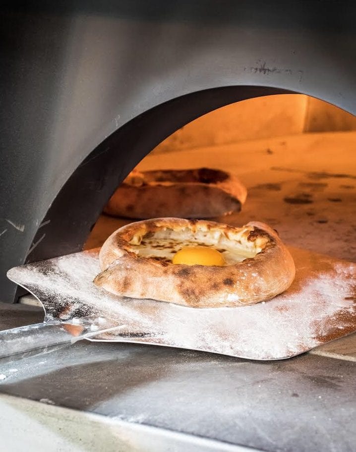 Adjarian khachapuri baking in a traditional oven